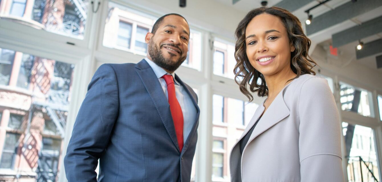 man and woman smiling inside building