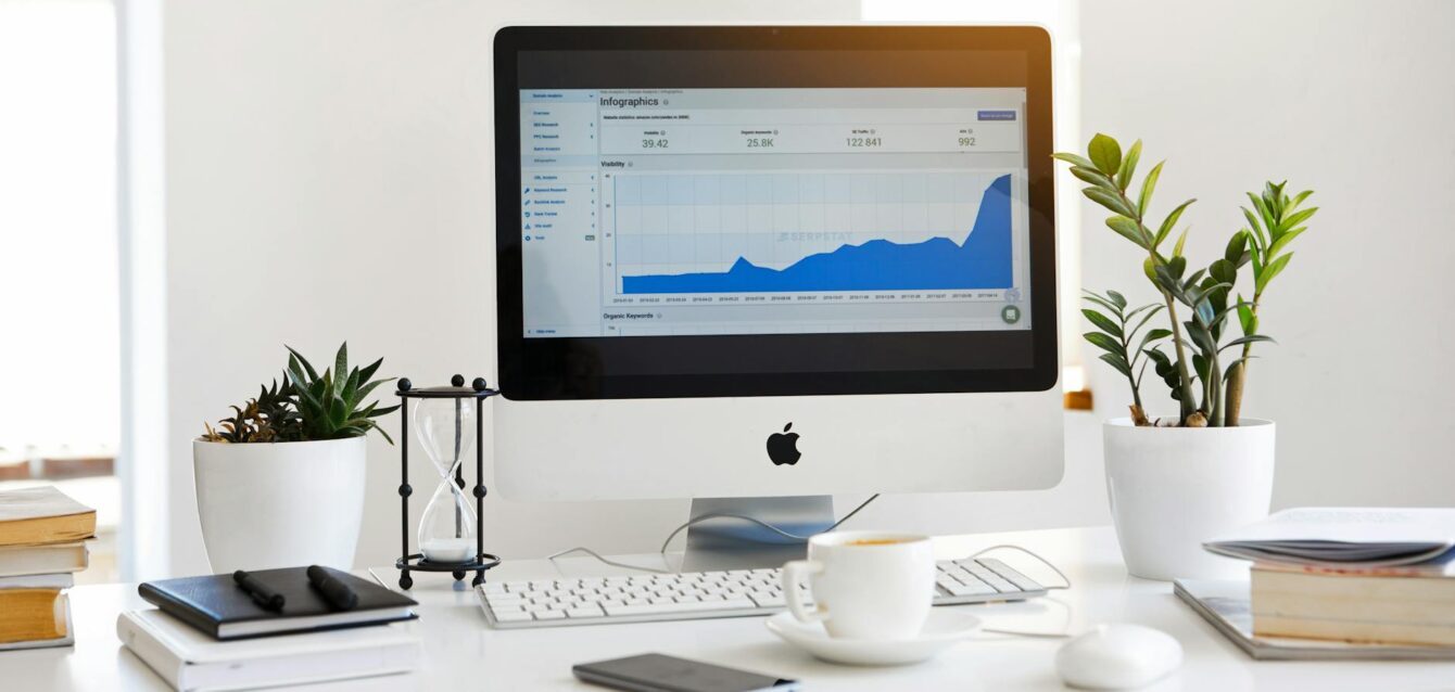 silver imac displaying line graph placed on desk